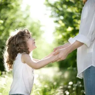 parent holding girl's hands - authoritative parenting is the best among the 4 styles of parenting
