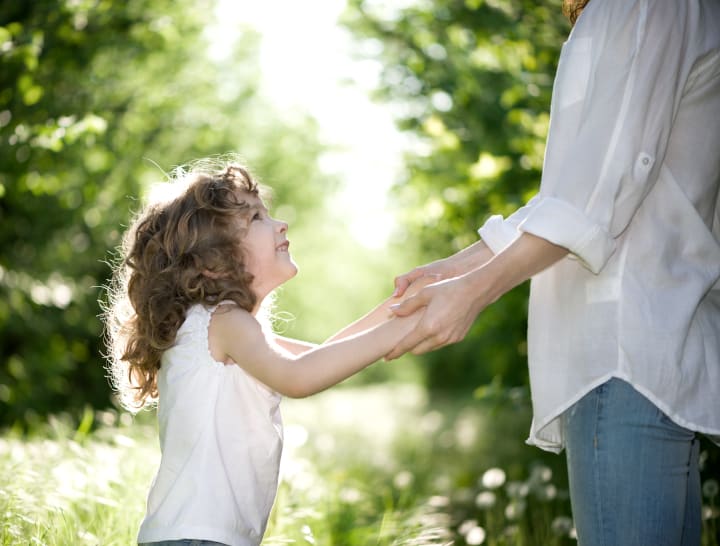 parent holding girl's hands - authoritative parenting is the best parenting definition among the 4 styles of parenting