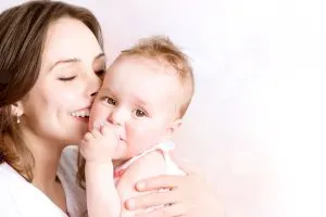 mother kisses baby happily