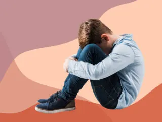 boy sits on ground crying