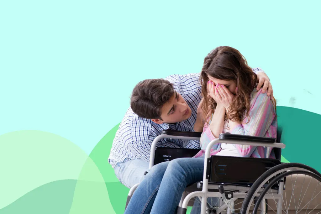 man comforting woman in wheelchair
