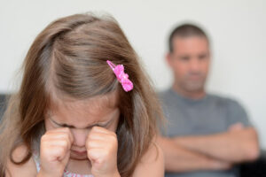 girl cries while dad ignores