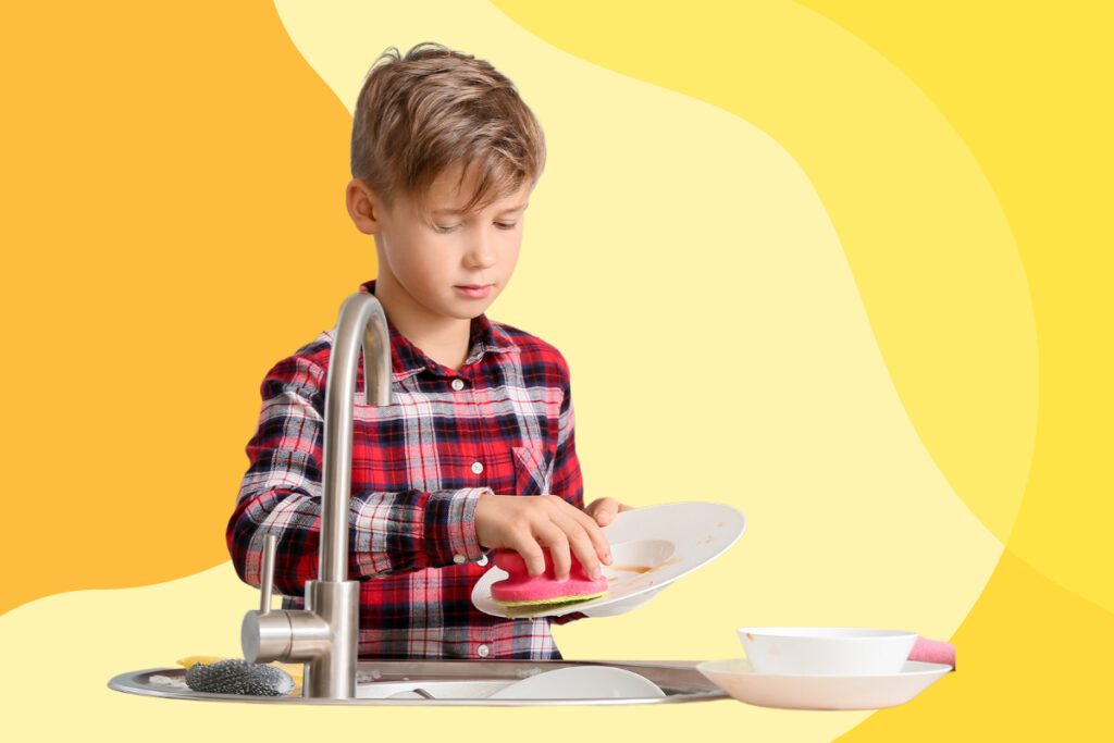 A young boy washing dishes.