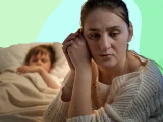 a mother lost in thought while her son peacefully sleeps on the bed