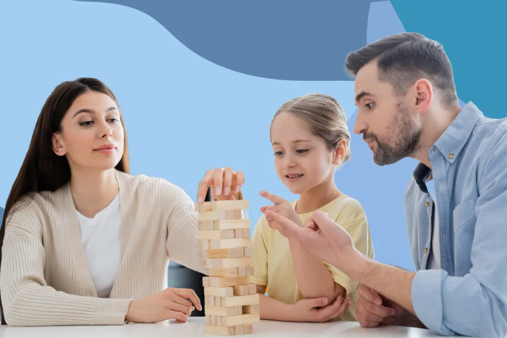 A young man and woman playing Jenga with a young girl.