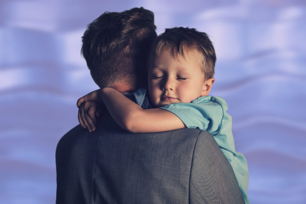 boy hugs father to calm nervous system preoccupied attachment style healing in adults