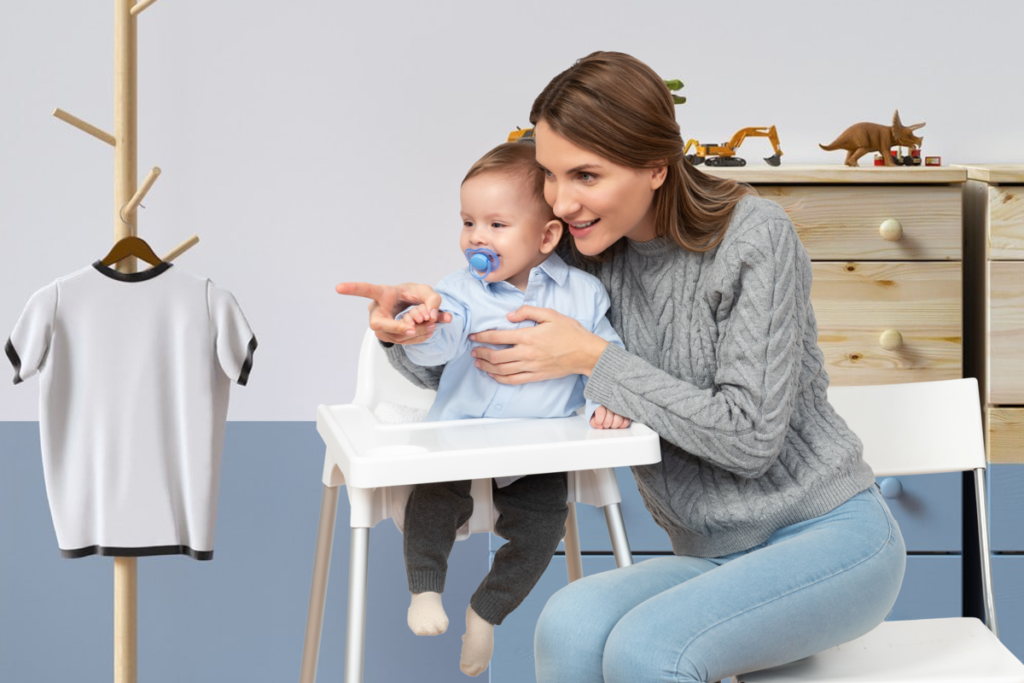 mom points at shirt to baby on high chair