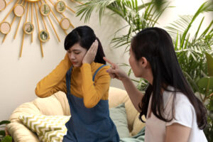 mother points finger at daughter who covers her ears parenting teens problems