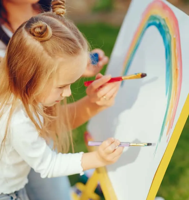 Girl paints rainbow with Mom on standup board - the importance of play in child development