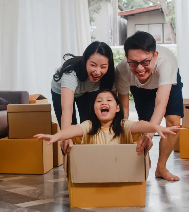 Mom and Dad push girl sitting in cardboard box to play - the importance of play in the early years