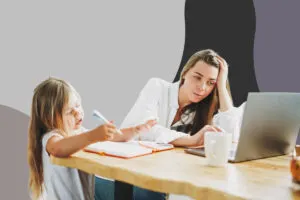 mother looks at laptop while daughter writes