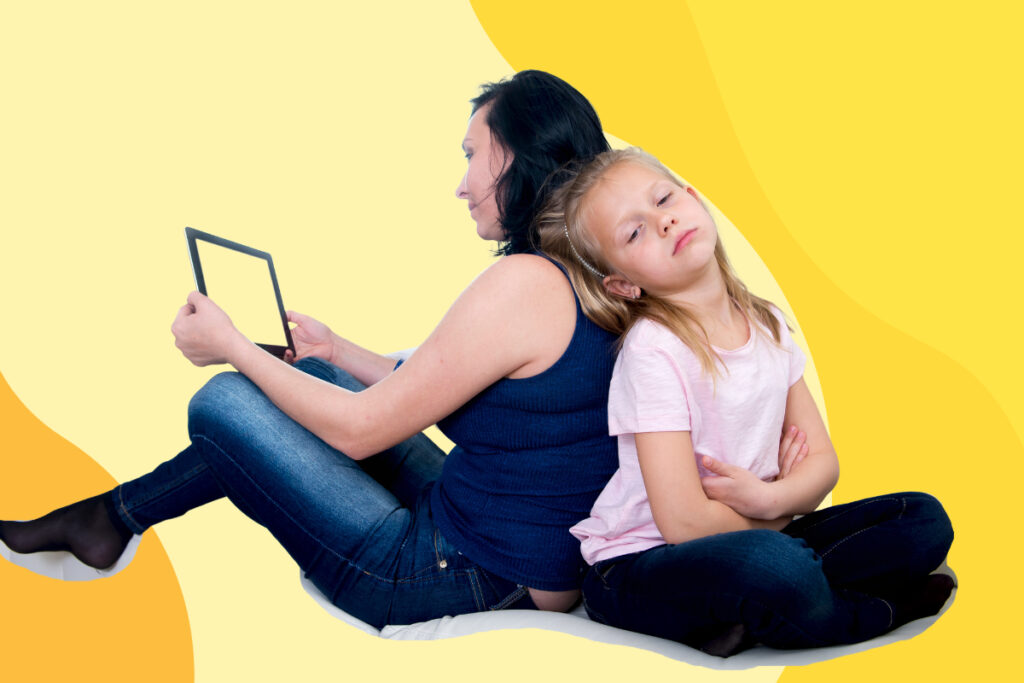 A woman plays on a screen while her bored daughter leans against her back.