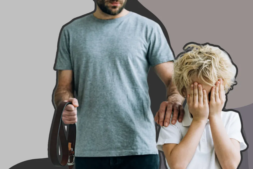 The father holds a belt in one hand while placing the other hand on his son's shoulder, as the son covers his face with both hands.